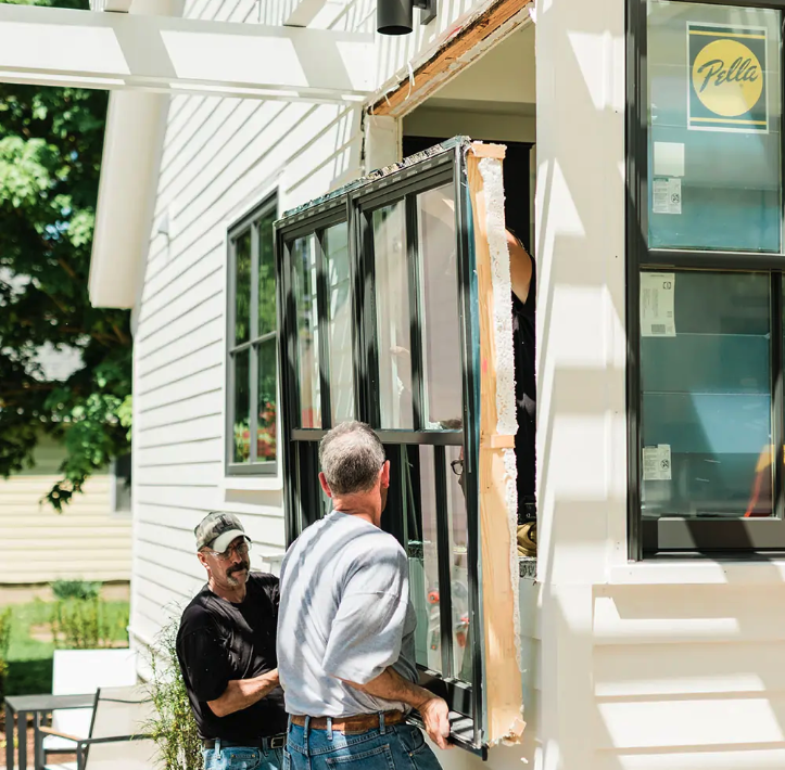two men installing a pella window on a home