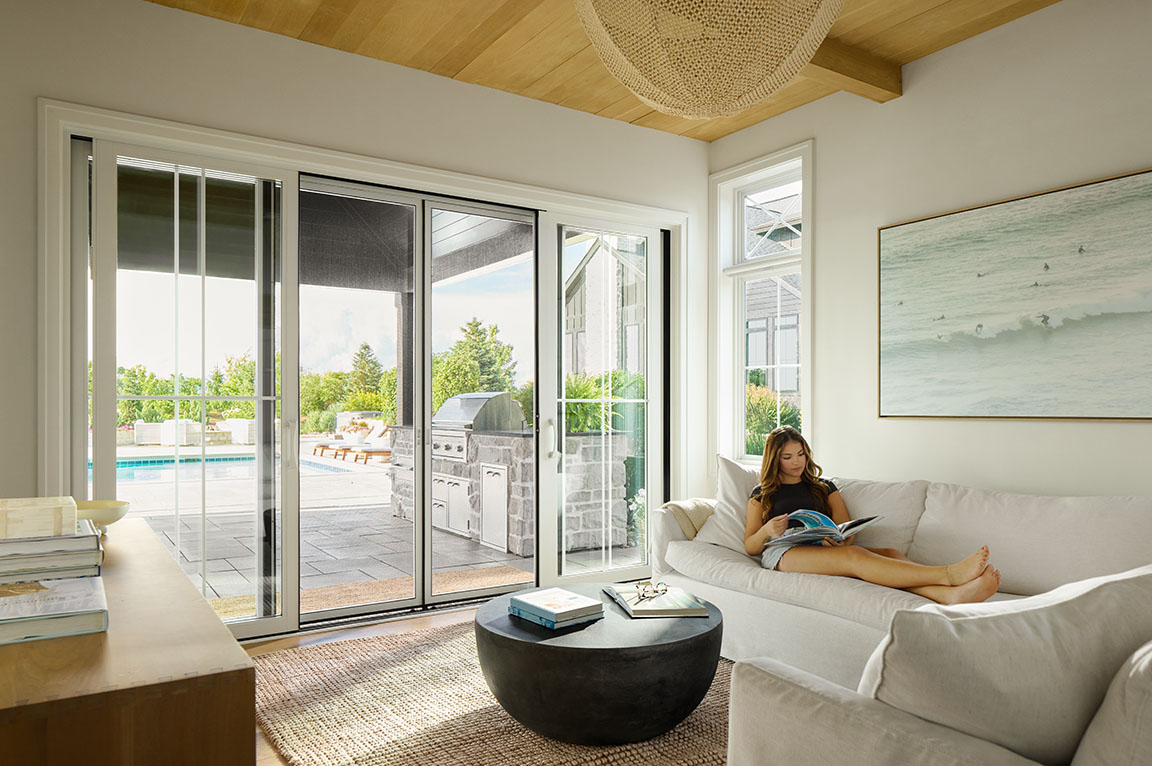 pella-white-4-panel-sliding-patio-door a woman inside her home next to pella patio doors